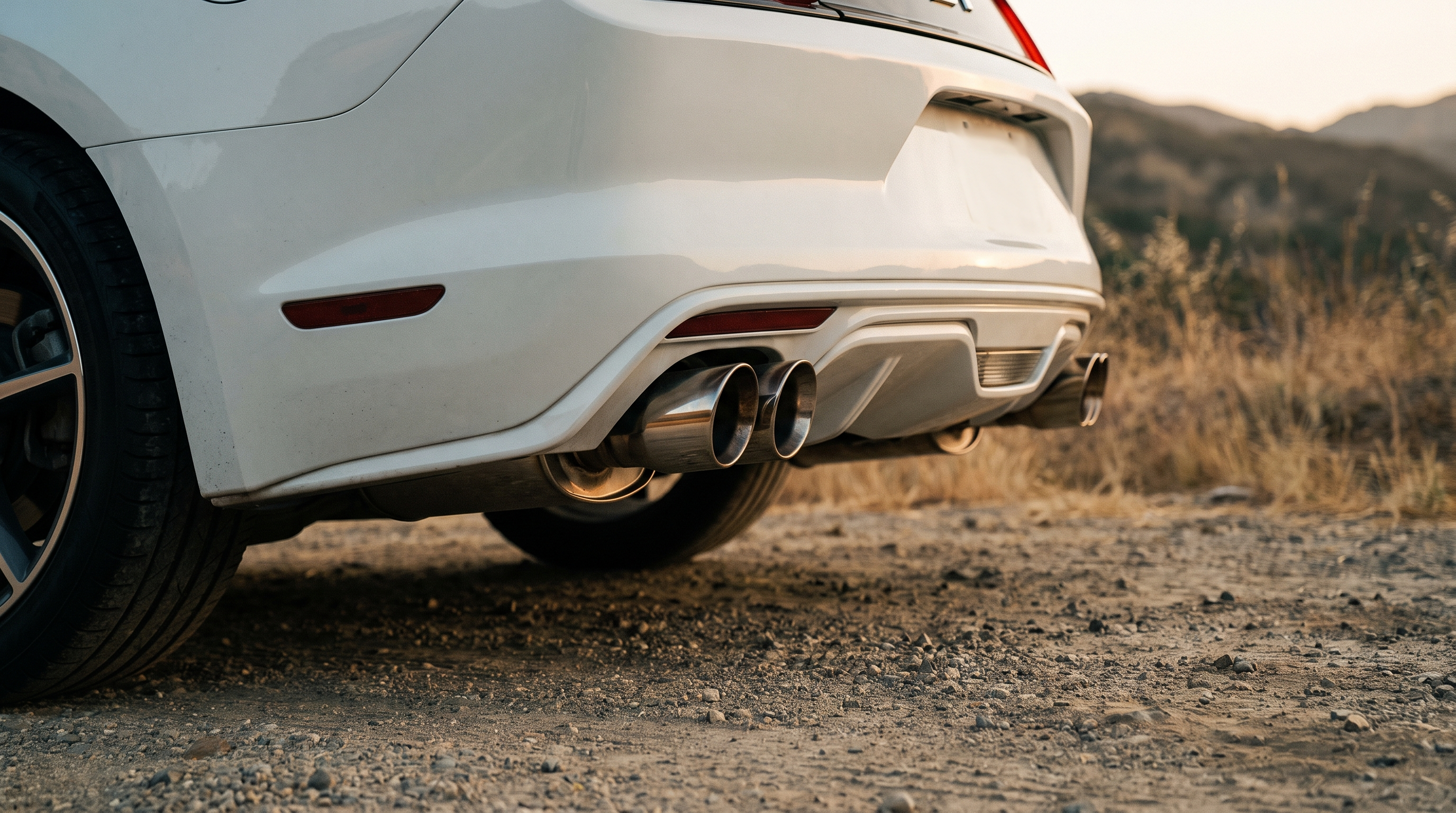 White S550 Ford Mustang GT rear bumper with quad polished exhaust tips at golden hour