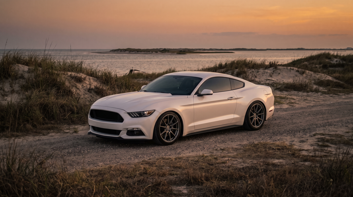 Pearl white S550 Ford Mustang GT on a Texas Gulf coast highway at golden hour