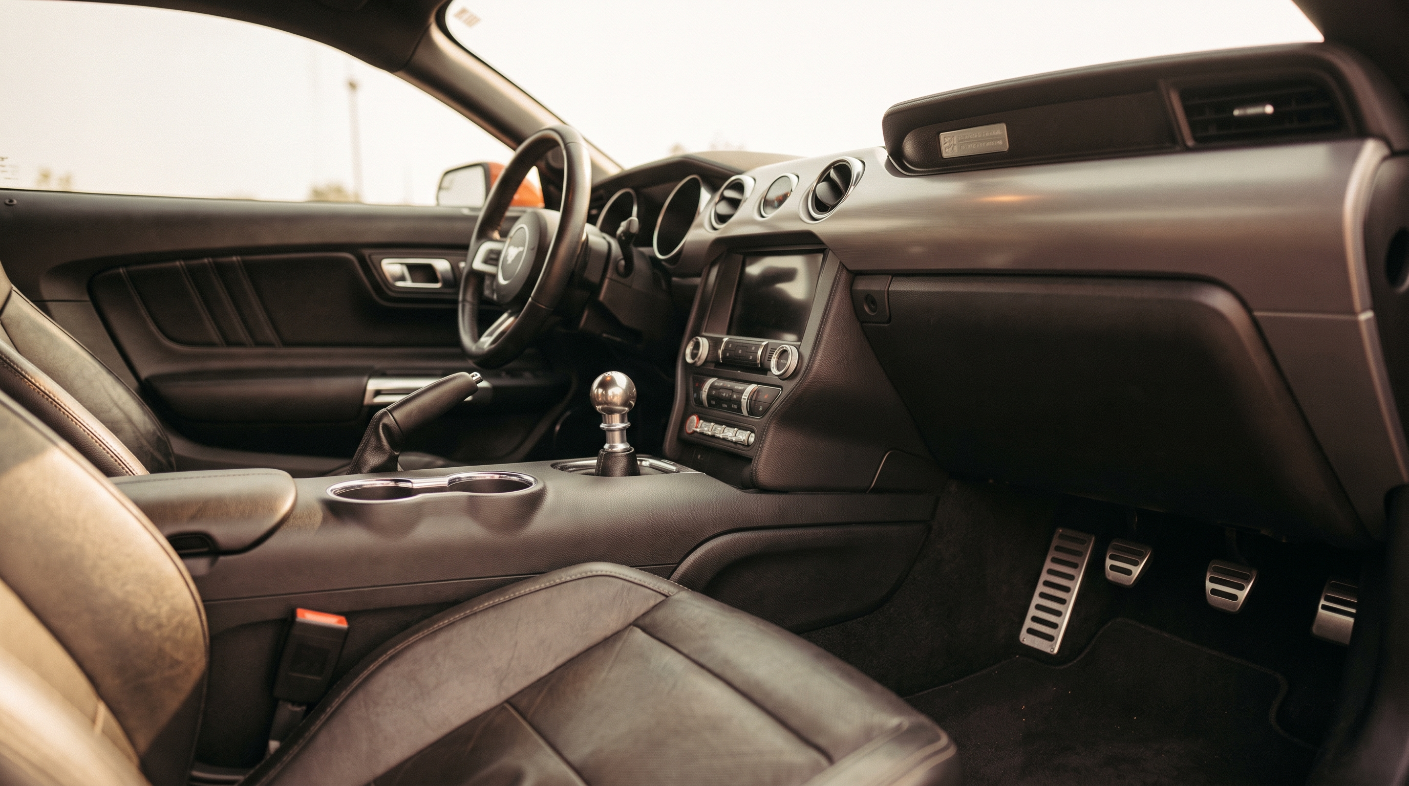 Interior of an S550 Ford Mustang GT showing the manual six-speed shifter and pedals
