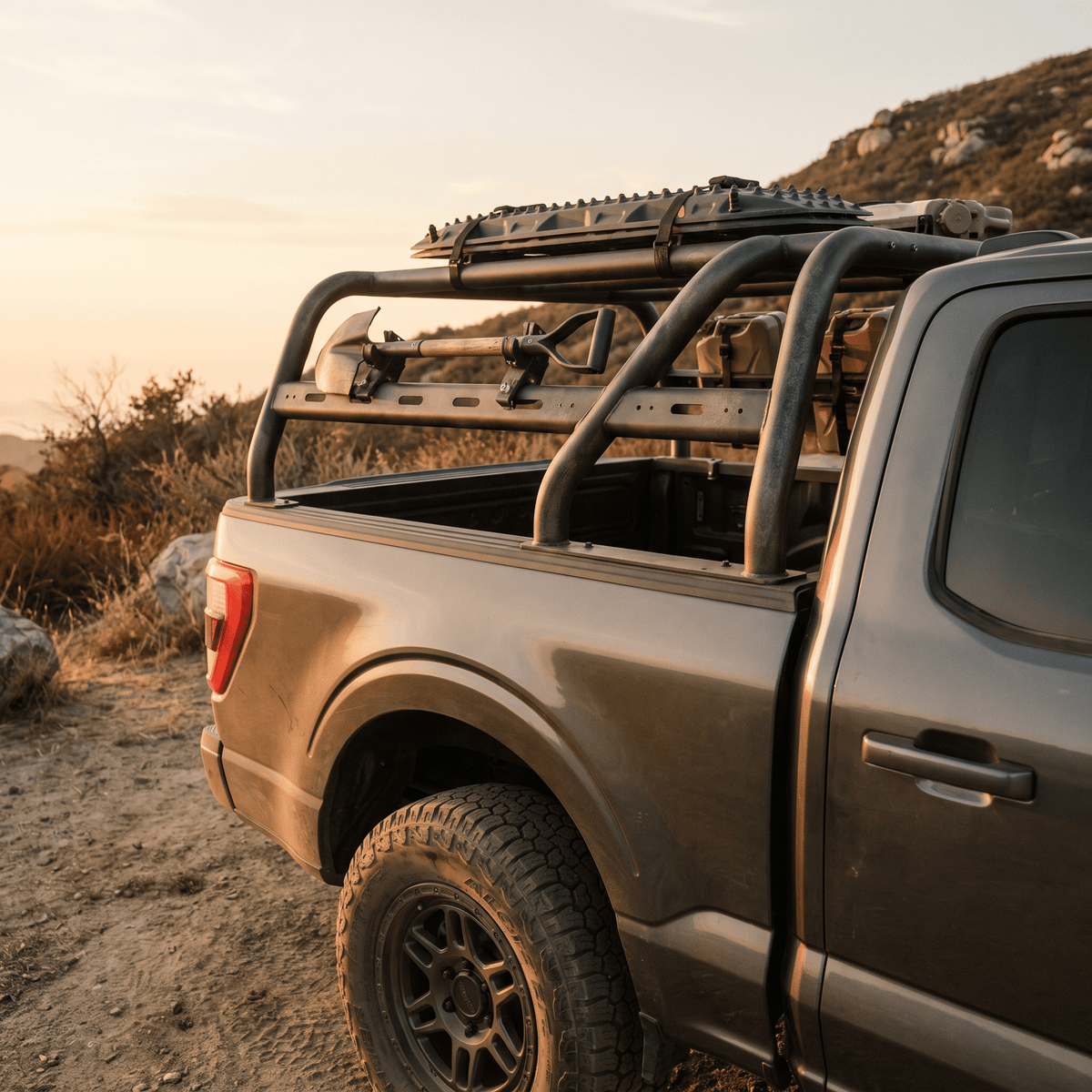 Black tubular roof rack on gray pickup truck with traction boards and shovel for off-road adventure