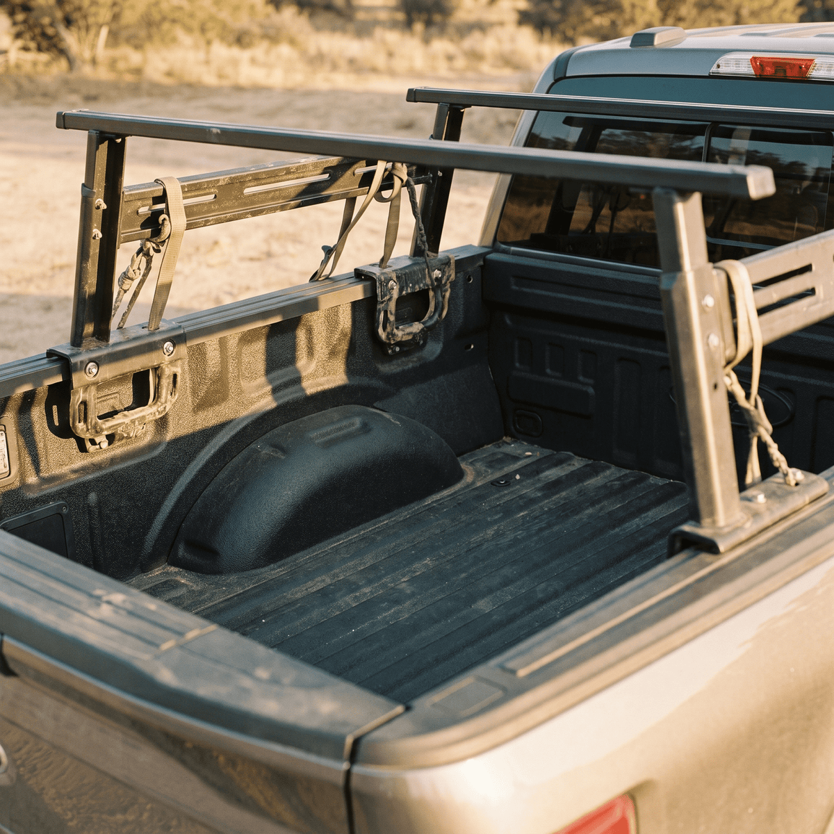 black metal truck bed rack with crossbars and tie-down straps for pickup cargo