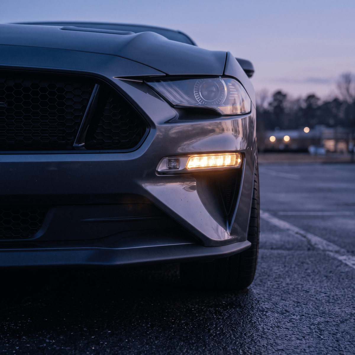 Amber LED fog light bar on dark gray Ford Mustang front bumper