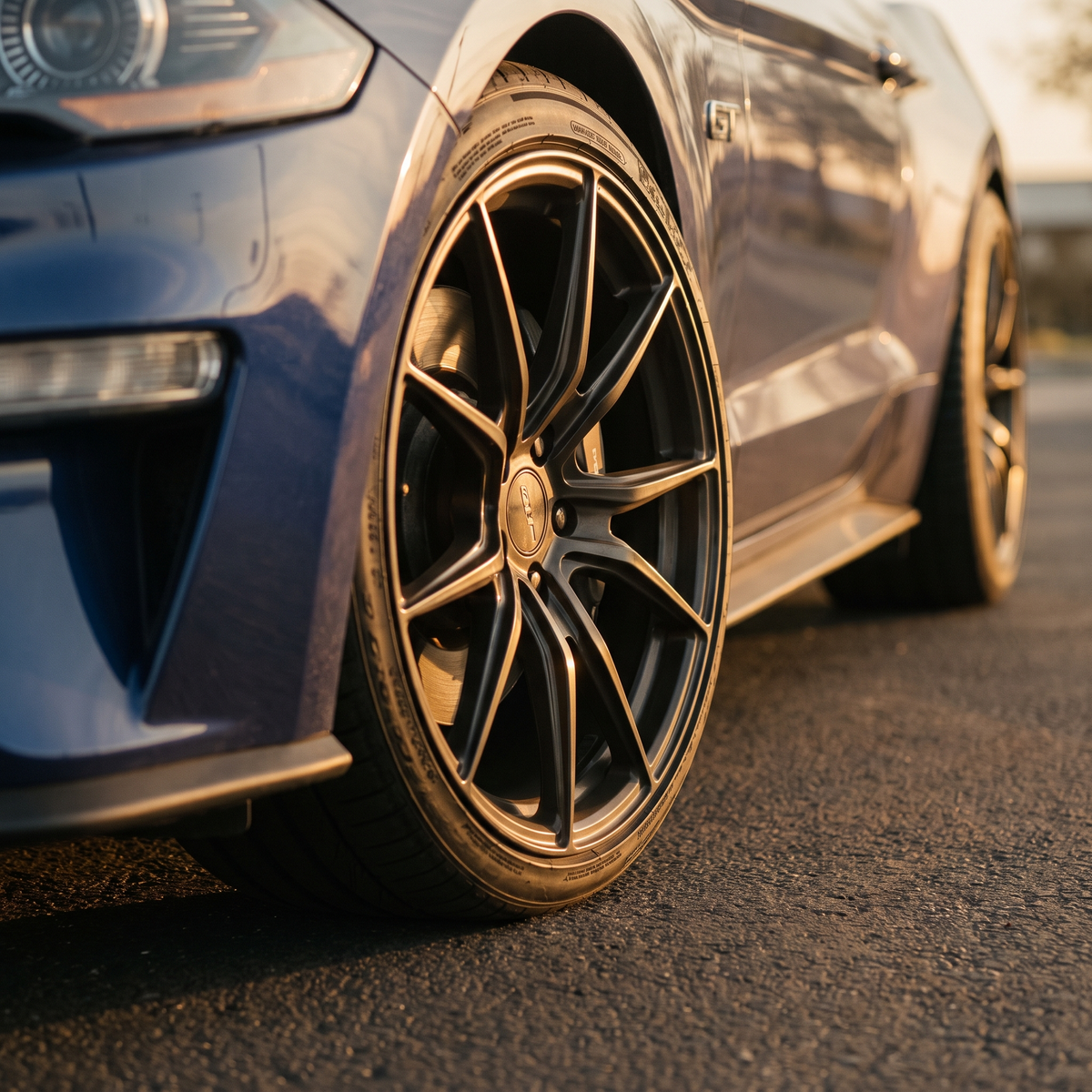 Blue 2015-2023 S550 Ford Mustang GT on a premium forged wheel at golden hour