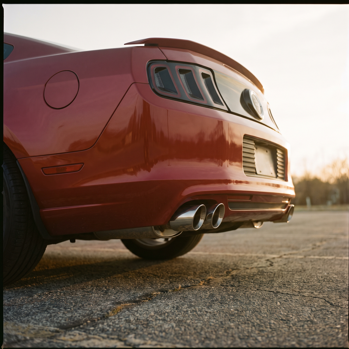 Red 2011-2014 S197 Ford Mustang GT with a cat-back exhaust at golden hour