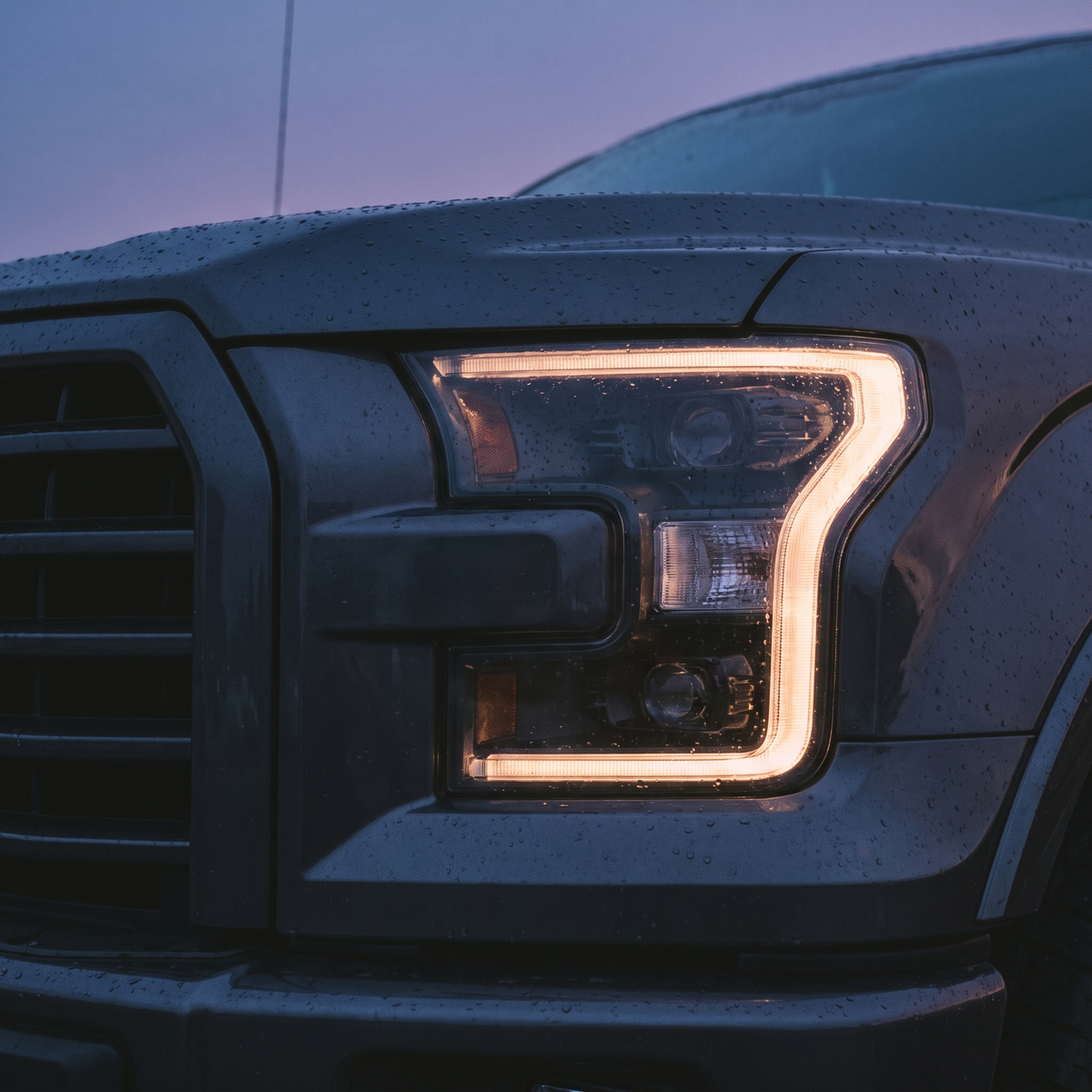 Aftermarket LED headlight lit on a 2015-2020 Ford F-150 at dusk